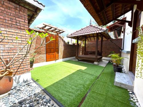 a backyard with a yard with green grass at Adagaya Villa - Villa With Private Pool, Without Pool in Pantai Cenang