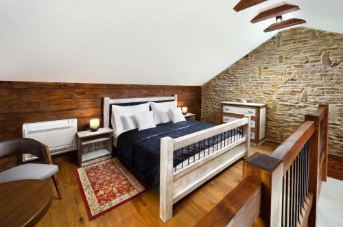 - une chambre avec un lit et un mur en briques dans l'établissement Castle Distillery, à Stará ľubovňa