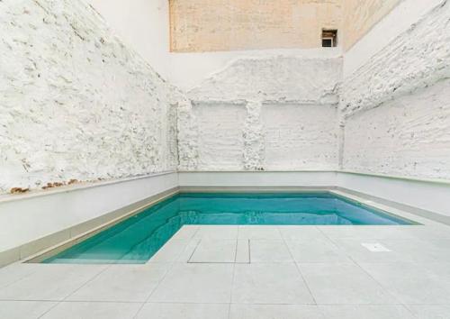 Una piscina en una habitación blanca con agua verde. en Apartamentos Bretón 17 Double Deluxe, en Alicante