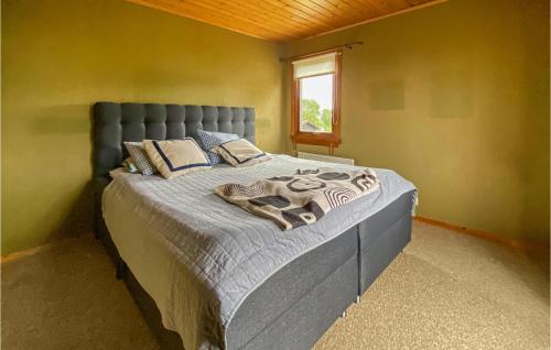 Väröbacka的住宿－3 Bedroom Nice Home In Vrbacka，一间卧室配有一张带蓝色床头板的床和窗户
