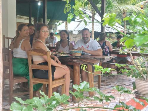 een groep mensen die aan een tafel zitten bij Hostel Wunderbar in Puerto Lindo