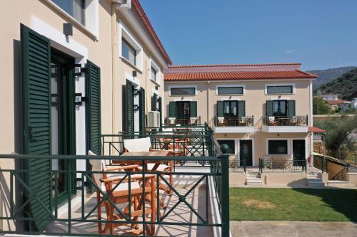 uma varanda com mesas e cadeiras num edifício em ΑΛΙΠΛΟΟΝ em Áyioi Pándes