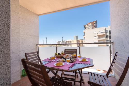 een tafel met een fruitschaal op een balkon bij Homely Fresh Apartment - Terrace & Garage in Póvoa de Varzim