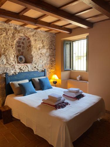 a bedroom with a large white bed with blue pillows at Can Clarós in Capmany
