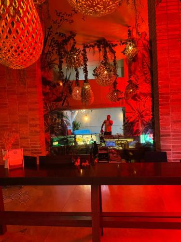 GINOs DUSHI SECRET FOR 8 PEOPLE في سان خوسيه: غرفة طعام مع إضاءة حمراء وطاولة