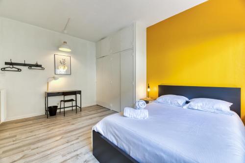 ein Schlafzimmer mit einem großen Bett mit gelber Wand in der Unterkunft Le Général Appartement proche des quais ! in Rouen