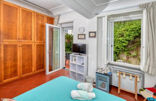 a bedroom with a blue bed and a window at Acquaviva 31 in Capri