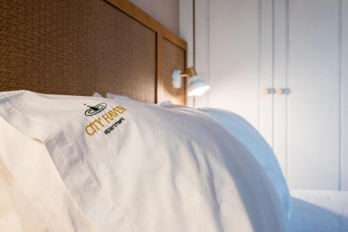 a white tshirt sitting on top of a bed at City Haven Apartment in Chania Town