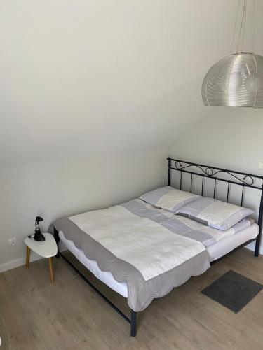 a bed in a bedroom with a white wall at Spanko in Sztutowo