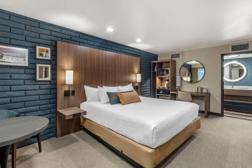 a bedroom with a bed and a desk and a table at The Gibson Hotel Great Falls, Ascend Hotel Collection in Great Falls