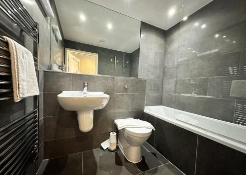a bathroom with a sink and a toilet and a tub at 6 Ocean Views in Newquay