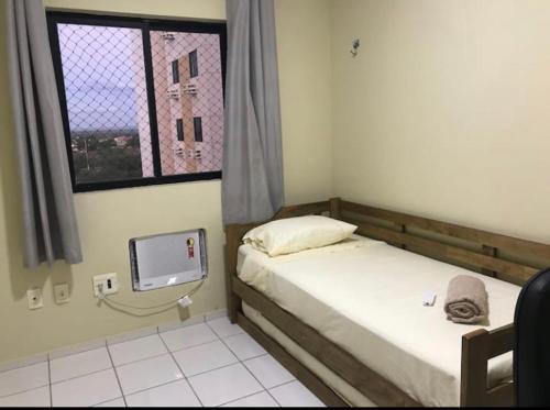 ein kleines Schlafzimmer mit zwei Betten und einem Fernseher in der Unterkunft Apartamento em Mossoró in Mossoró