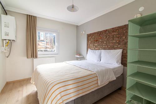 ein Schlafzimmer mit einem Bett und einer Ziegelwand in der Unterkunft Chic Apartment in Balat, Fatih with Balcony in Istanbul
