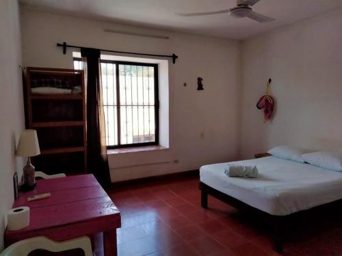 a bedroom with a bed and a window and a table at Casa de Ines y Victoria in Valladolid