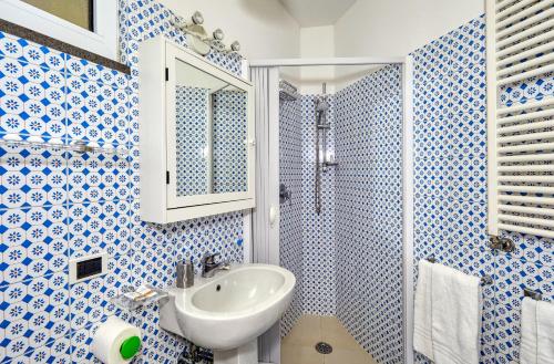 un bagno blu e bianco con lavandino e doccia di Acquaviva 31 a Capri