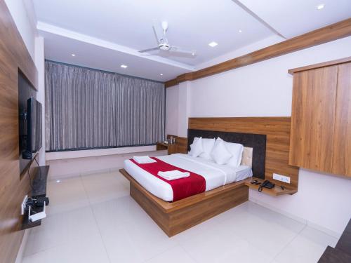 1 dormitorio con 1 cama y TV de pantalla plana en Hotel Chiranjeevi Kolhapur en Kolhapur