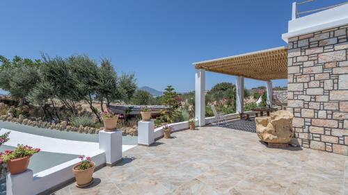a patio with potted plants and a pavilion at Milion Fantasy House in Adamas