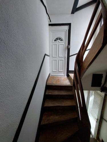 a hallway with a white door and stairs at Appartement Le Suly in Salins-les-Bains