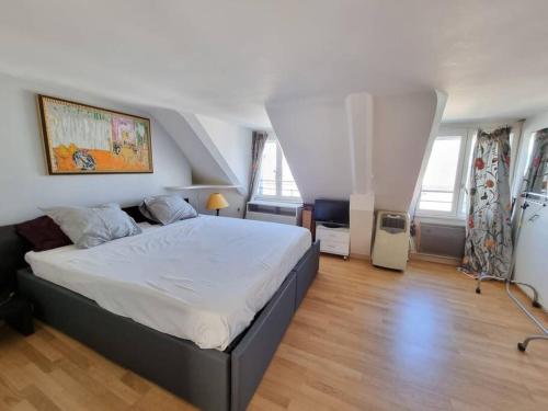 une chambre avec un grand lit dans une pièce dans l'établissement Superbe logement au centre de Paris, à Paris