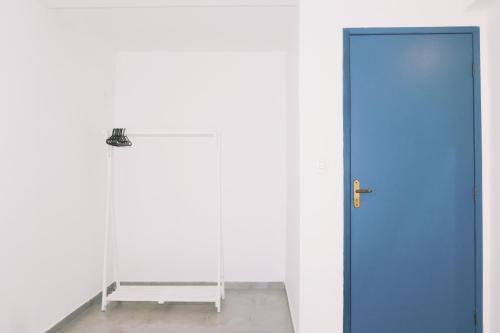 a blue door in a room with a white wall at Sea Wolf Hostel - Lagoa da Conceição in Florianópolis