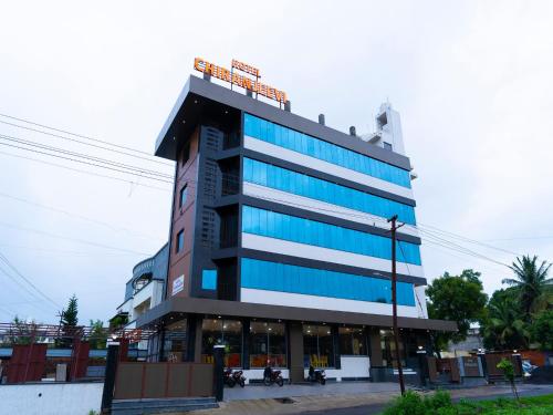 a tall building with blue windows on a street at Hotel Chiranjeevi Kolhapur in Kolhapur