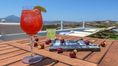 a drink sitting on top of a wooden table with cherries at Milion Fantasy House in Adamas