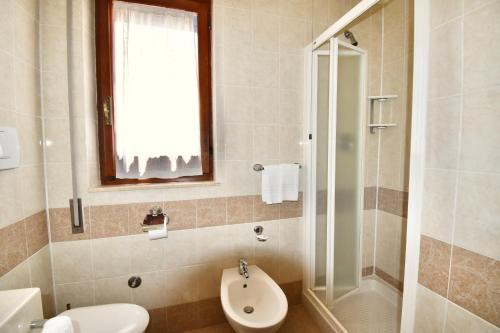 a bathroom with a toilet sink and a shower at Cossyra Hotel in Pantelleria