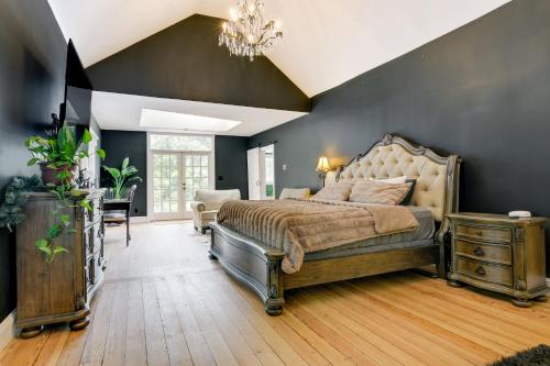 a bedroom with a large bed and a chandelier at Spacious Durham Home with Fire Pit and Hot Tub! in Durham