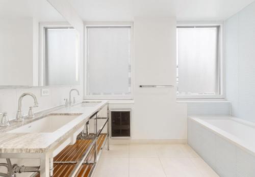 a white kitchen with two sinks and two windows at OLD Luxury 5 Bedroom Apartment Near 5th Avenue Manhattan in New York