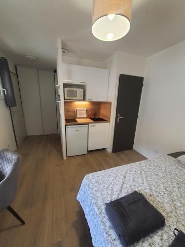 Cette petite chambre comprend un lit et une cuisine. dans l'établissement Studio au calme Espace extérieur Parking gratuit dans la rue, à Grenoble