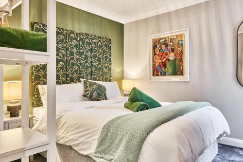 - une chambre dotée d'un lit avec des draps blancs et des murs verts dans l'établissement 44 North, à Londonderry County Borough