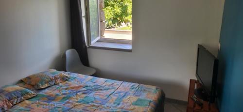 une chambre avec un lit et une fenêtre dans l'établissement Maisonnette en pierre rénovée, à Lamastre