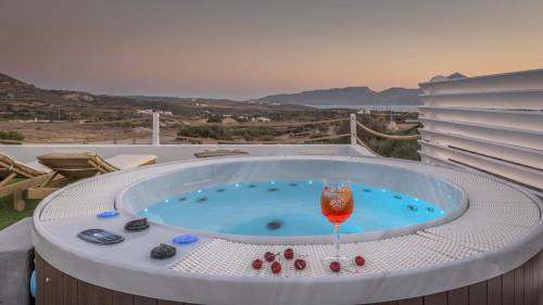a hot tub with a glass of wine in it at Milion Fantasy House in Adamas