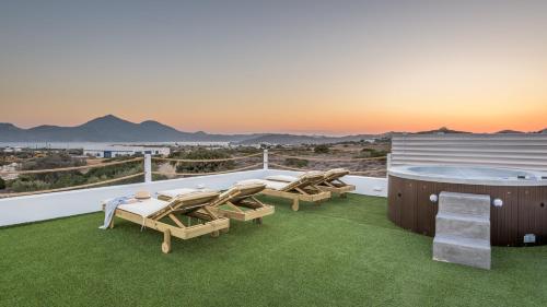a patio with a hot tub and chairs on a roof at Milion Fantasy House in Adamas