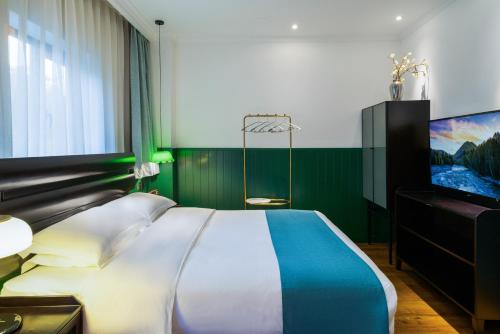 a bedroom with a bed and a flat screen tv at Hangzhou Lanshe hotel in Hangzhou