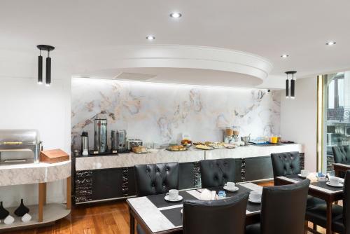 a dining room with a table and chairs and a kitchen at Imperial Park Hotel in Buenos Aires