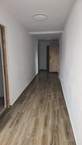 ein leeres Zimmer mit Holzboden und weißen Wänden in der Unterkunft Casa Mariș in Cluj-Napoca