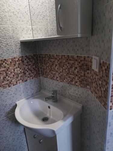 ein Badezimmer mit einem weißen Waschbecken und einem Schrank in der Unterkunft Casa Mariș in Cluj-Napoca