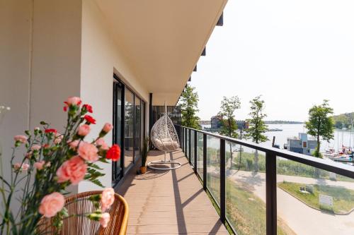 a balcony with a view of the water at Lake Club Apartments by LoftAffair in Mikołajki
