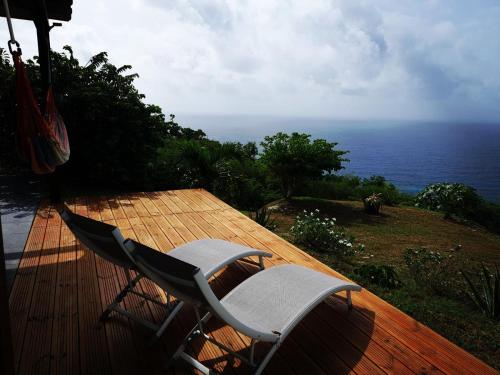 a chair sitting on a deck overlooking the ocean at Habitation Noelesse in Beauregard