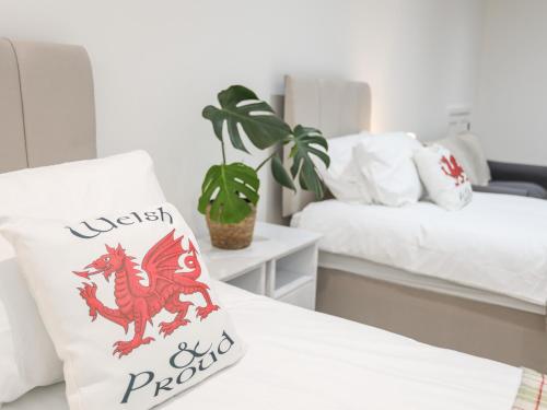 a bed with a pillow with a dragon on it at The School House in Holyhead