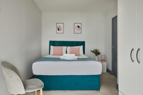 ein Schlafzimmer mit einem Bett und einem Stuhl in der Unterkunft Ealing Broadway by Viridian Apartments in Ealing