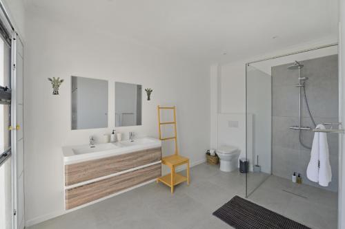 a bathroom with a tub and a sink and a toilet at Camps Bay Villa Views Pool Garden in Cape Town