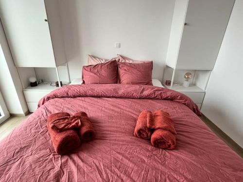 Una cama con mantas rojas y almohadas. en Gezinsappartement in Middelkerke - Noort-C, en Middelkerke
