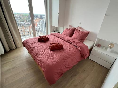 een slaapkamer met een roze bed met twee zakken erop bij Gezinsappartement in Middelkerke - Noort-C in Middelkerke