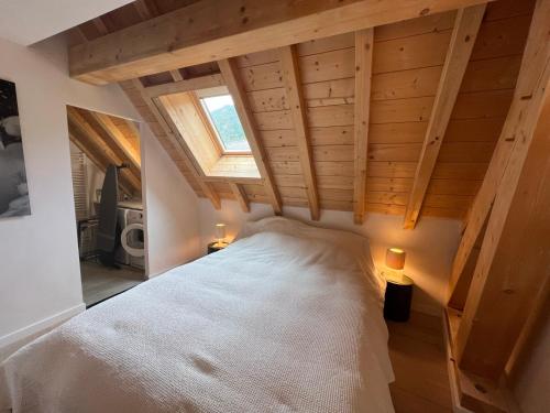 Un dormitorio con una gran cama blanca con ventana. en Saint Eldrade, en Le Monêtier-les-Bains