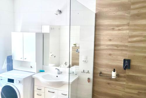 a bathroom with a sink and a washing machine at Dom nad Jeziorami in Łubowo