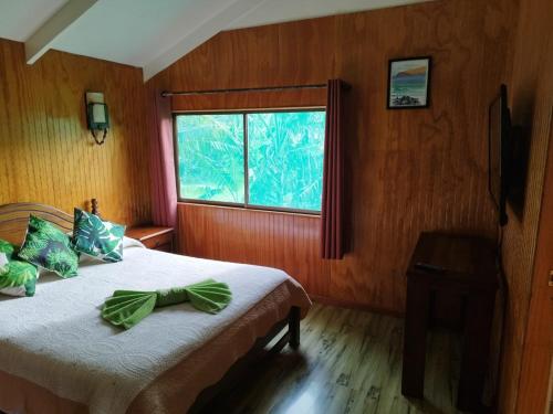 1 dormitorio con 1 cama y ventana grande en Hostal Avareipua, en Hanga Roa
