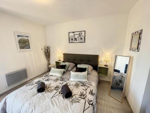 une chambre avec un grand lit et un miroir dans l'établissement Le Panoramique - Sublime vue sur la Cité, à Carcassonne