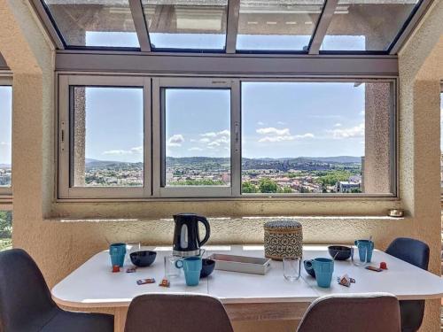 une table avec une cafetière dessus devant une fenêtre dans l'établissement Le Panoramique - Sublime vue sur la Cité, à Carcassonne